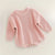 Cute pink chunky knit baby romper with long sleeves, ideal for winter comfort and style.