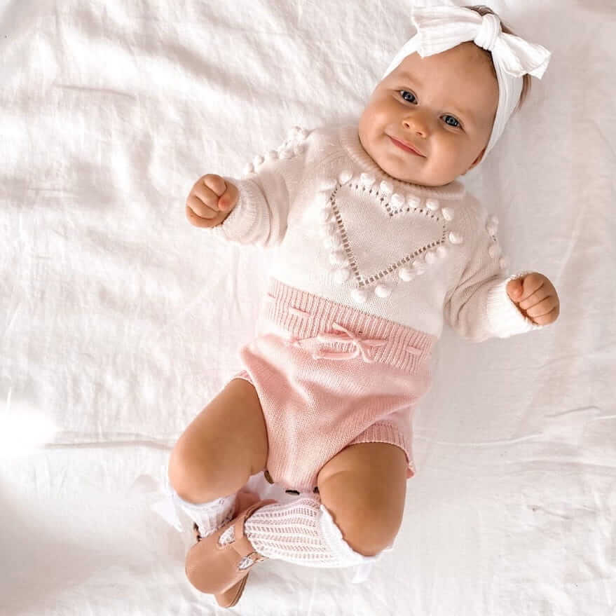 Baby girl wearing our knit heart romper, bow lace socks and vintage t-bar shoes