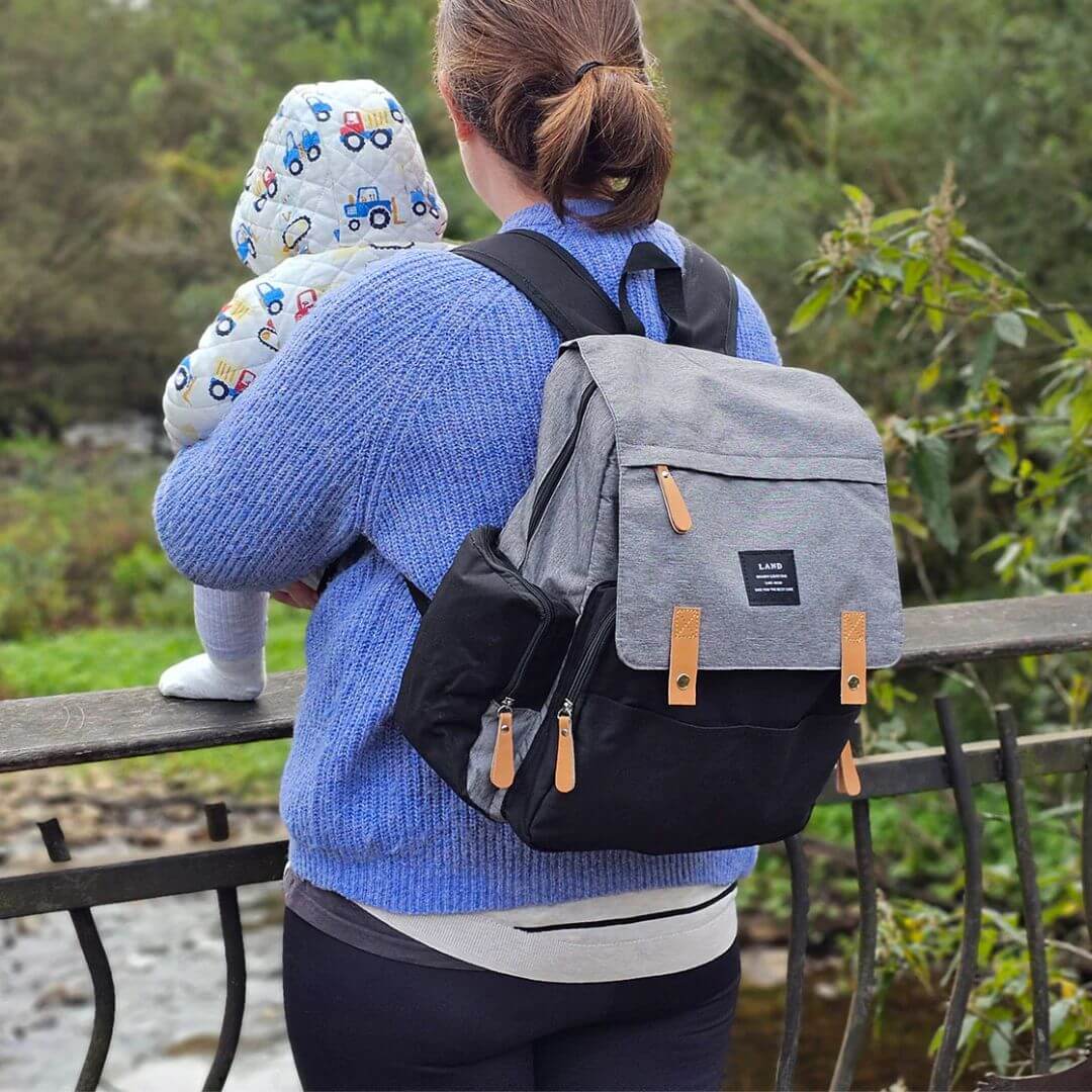 Mum with baby - using LAND nappy bag, ideal for travel (in grey and black)