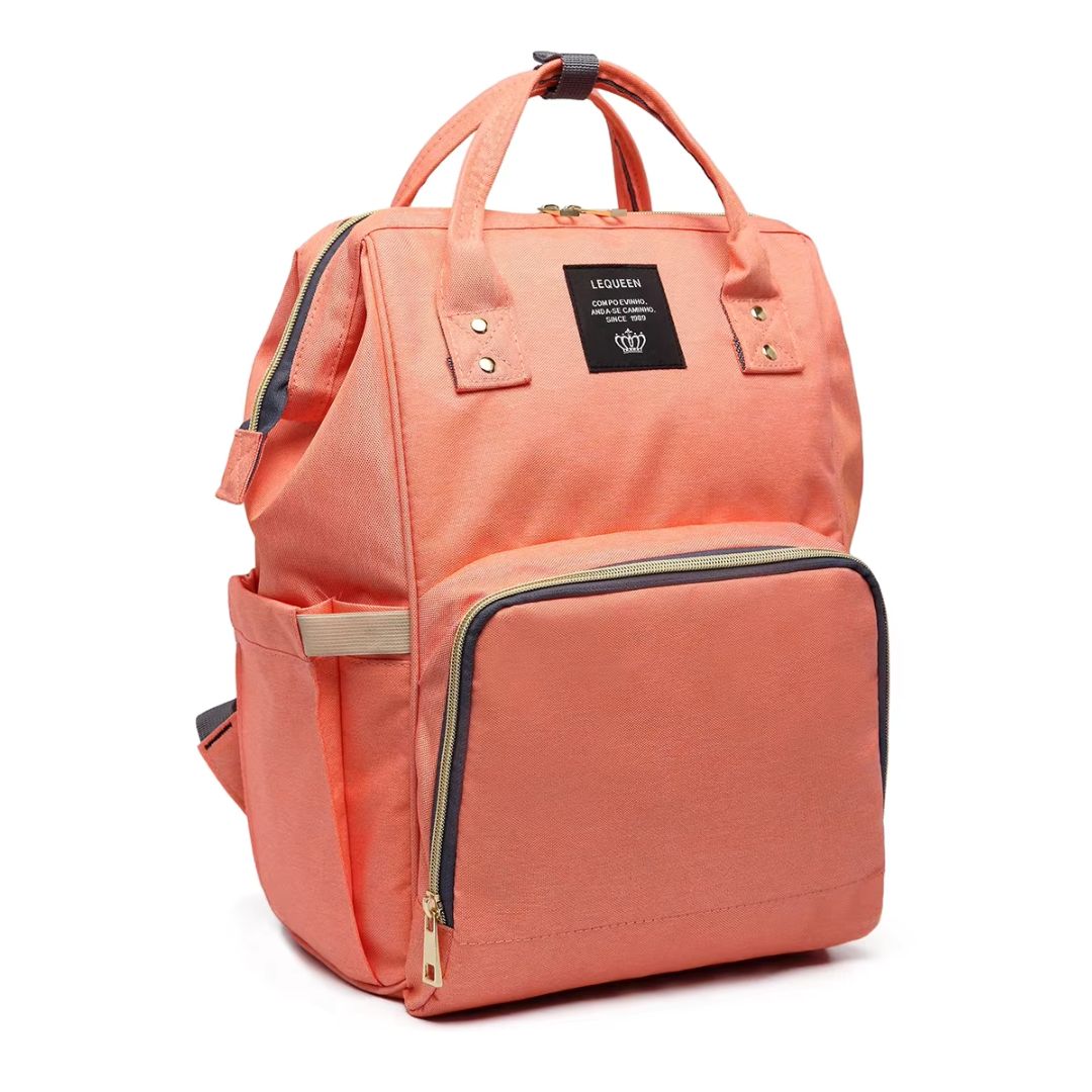 Stylish LeQueen Nappy Bag in coral colour - angled shot showing the expandable bottle pocket on the side.
