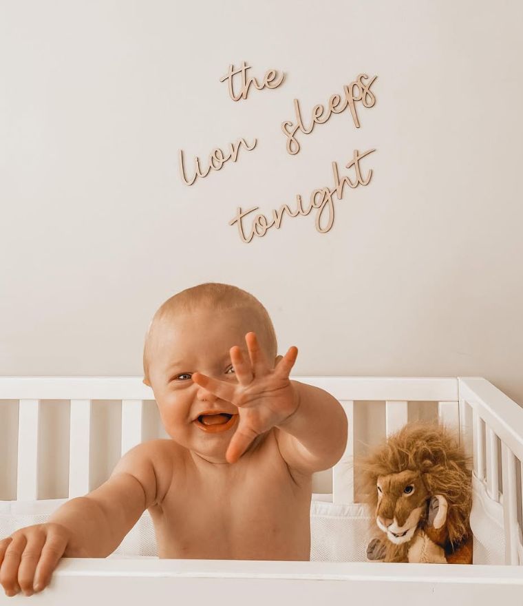 The Lion Sleeps Tonight Wooden Wall Script, hung above cot with baby