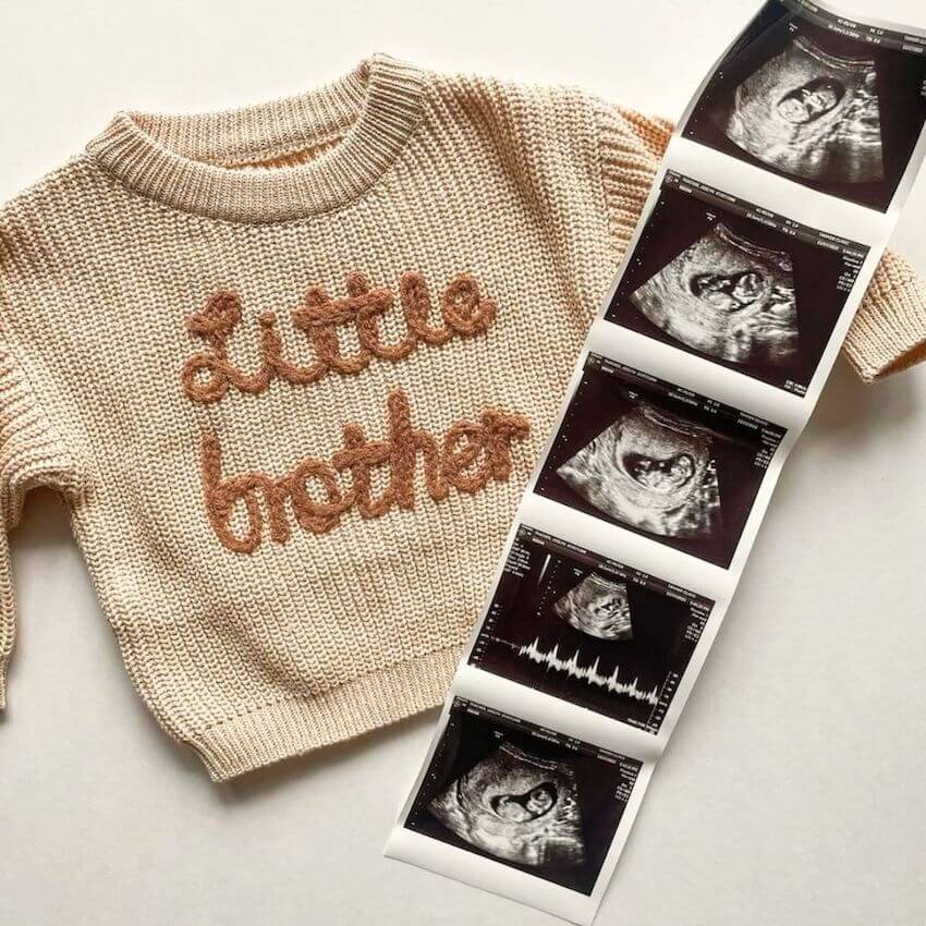 Baby announcement photo idea, featuring a Little Brother jumper and ultrasound images