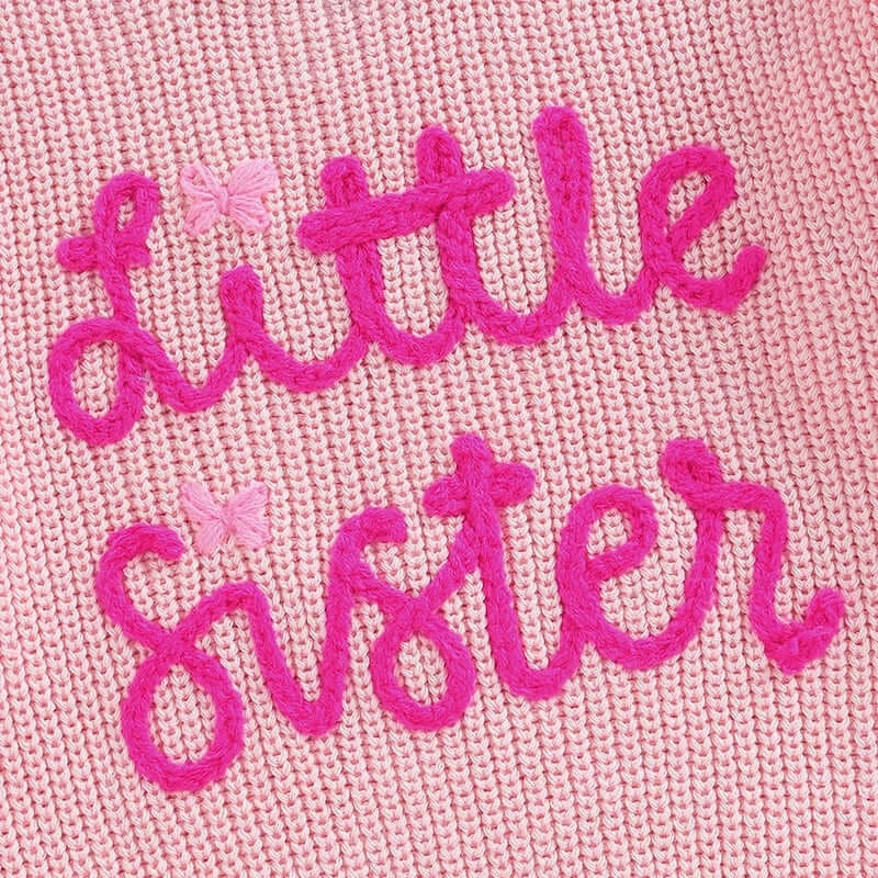 Little Sister Pink Jumper with embroidered text 'Little Sister' on soft knitted fabric.