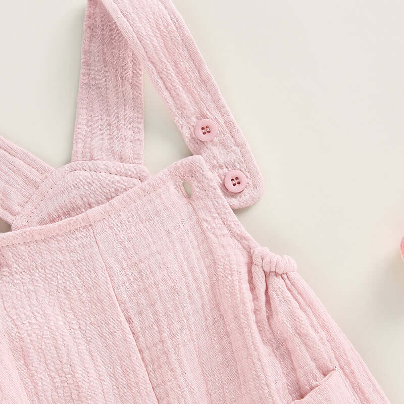 Cotton muslin baby romper in blush pink - closeup of adjustable straps