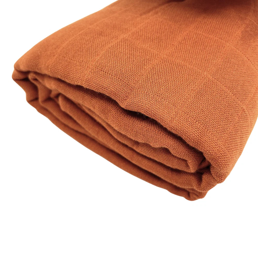 Closeup of muslin baby wrap in rust by Little Renegade Company