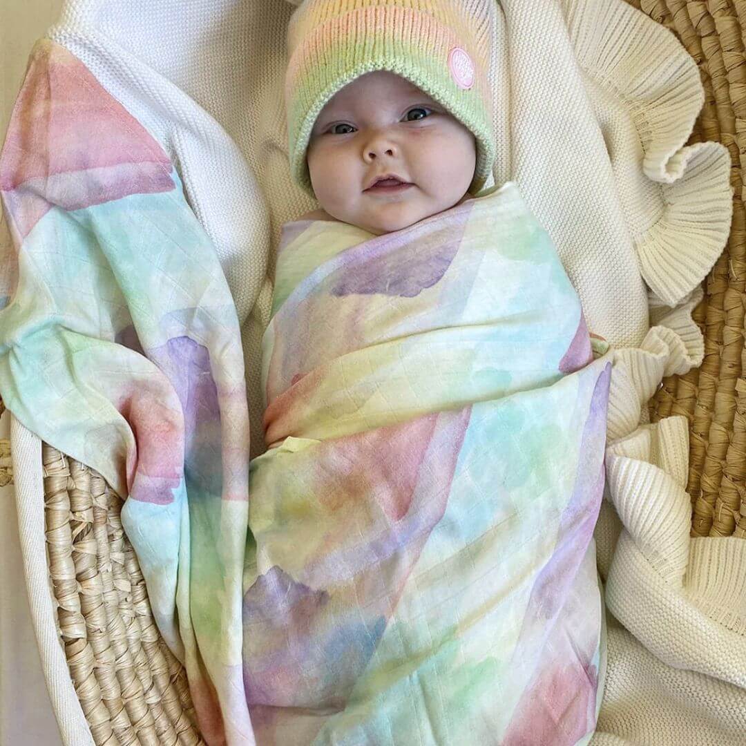 Baby wrapped in muslin swaddle by Little Renegade Company