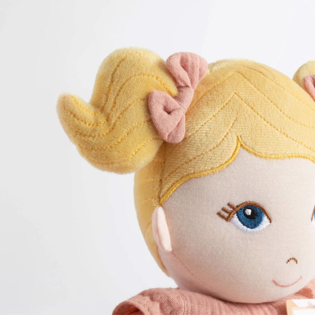 Close-up of My First Doll - Lola with blonde pigtails and embroidered blue eyes