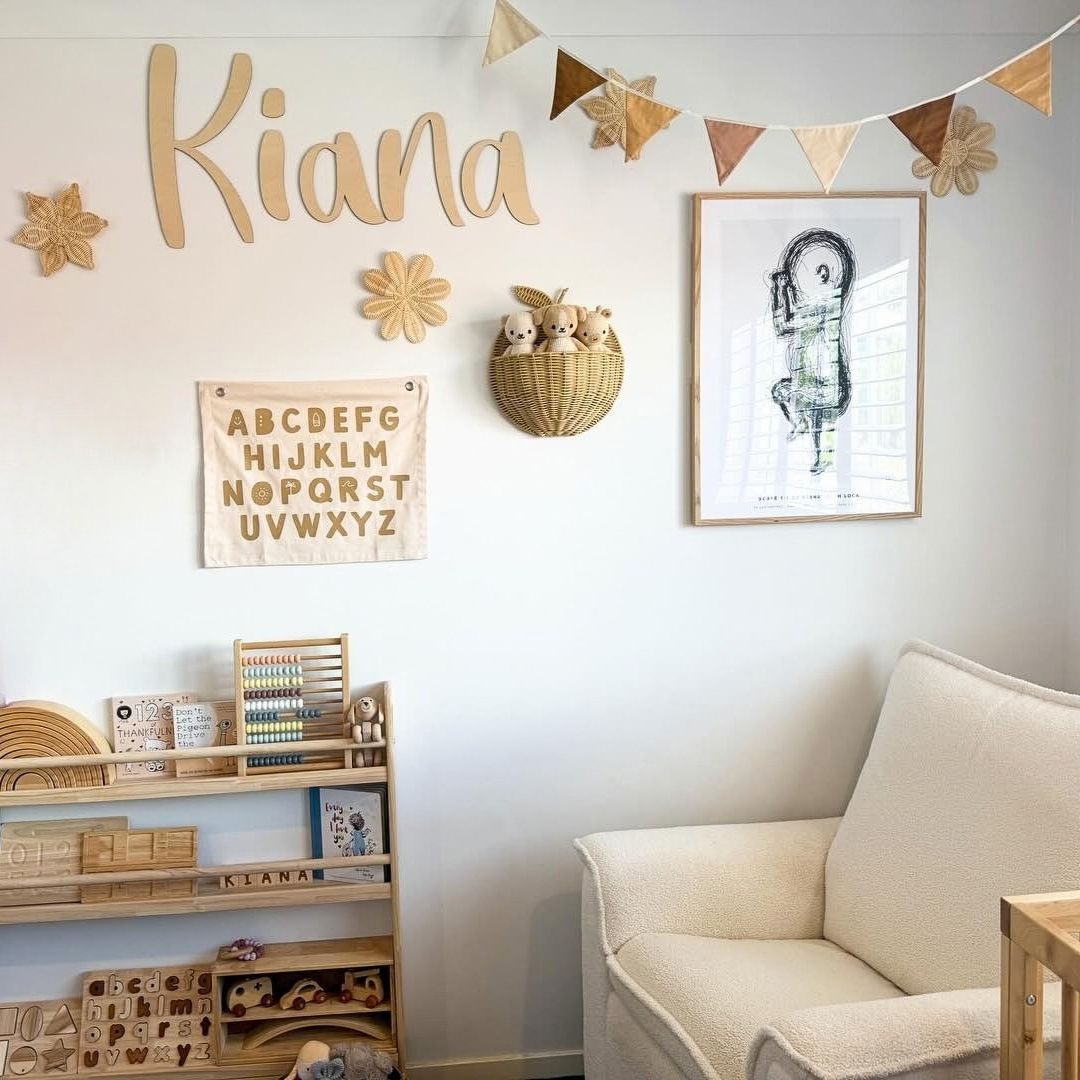 Nursery name sign in natural wood, styled on the wall in a child's nursery