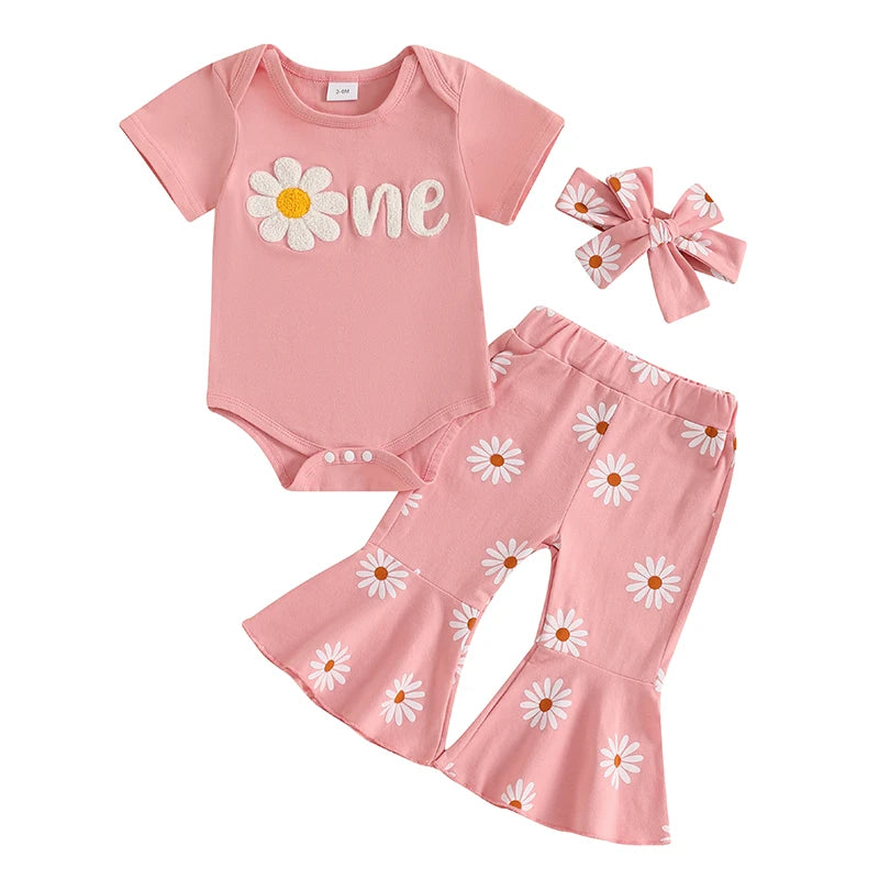 Baby girl's first birthday outfit set featuring a pink "one" bodysuit, floral flared pants, and a daisy bow headband.