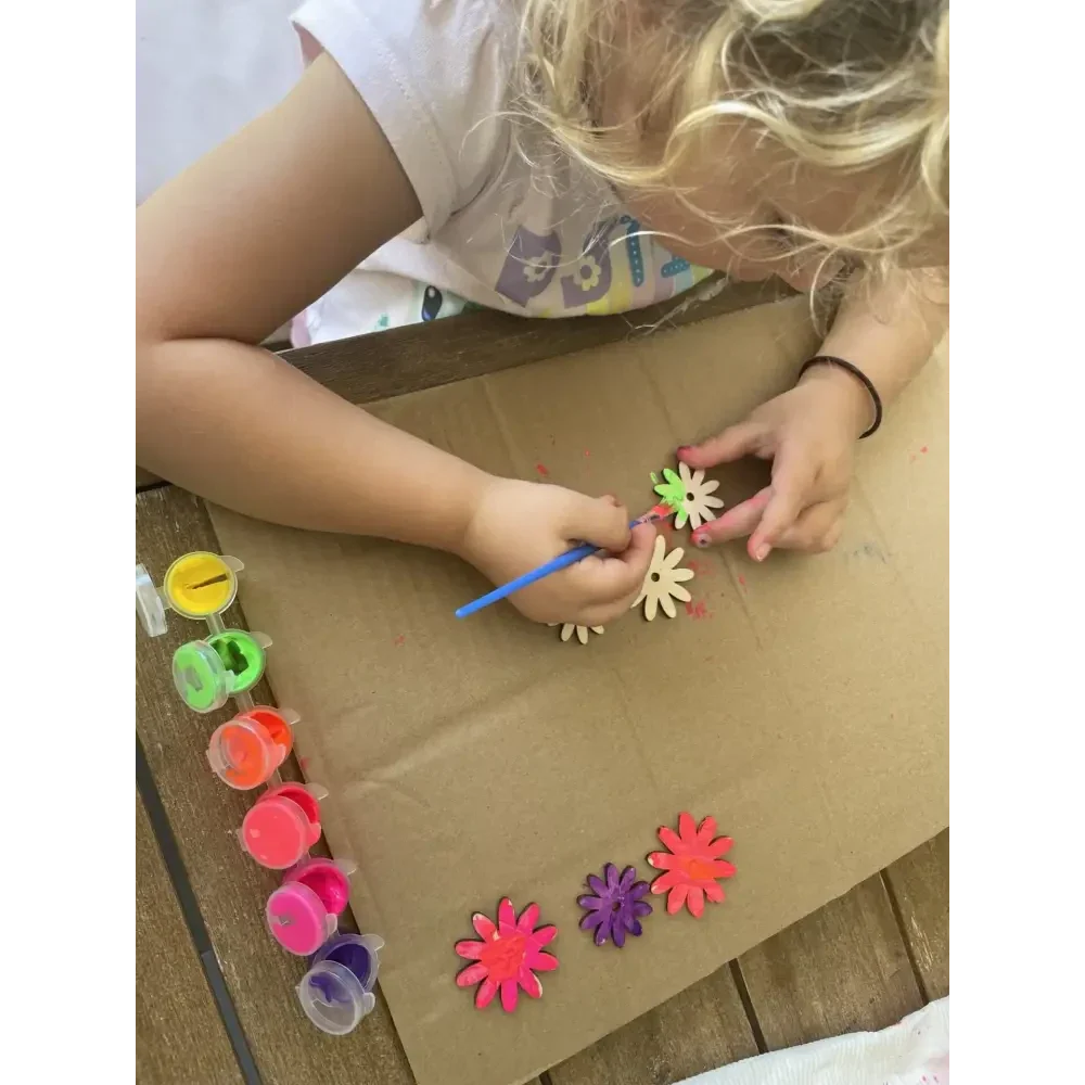 Child painting with their personalised wooden flower kit