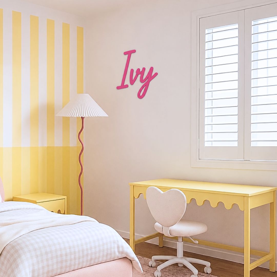 Girl's bedroom featuring a pink coloured name sign on the wall