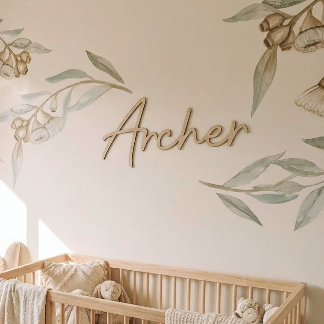 Wooden name sign 'Archer' hanging on nursery wall