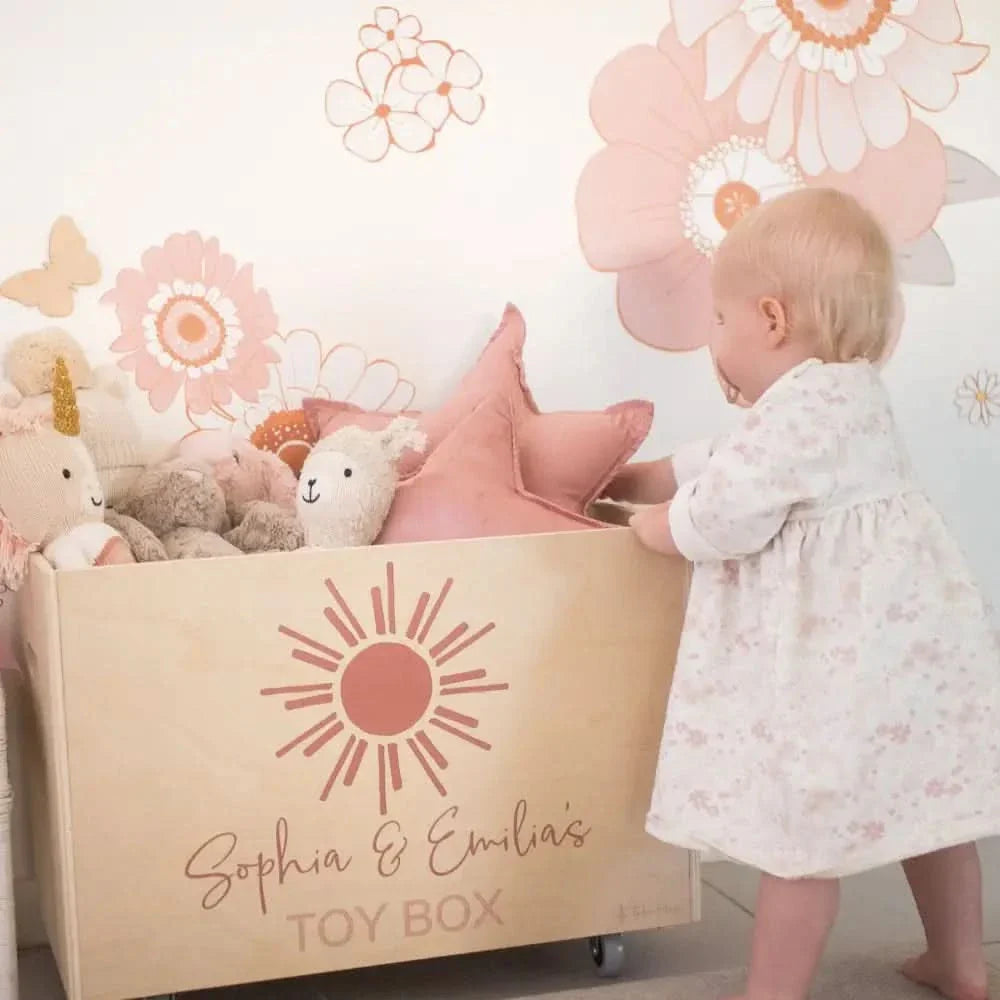 A child pulling toys from a Personalised Wooden Toy Box featuring their name.