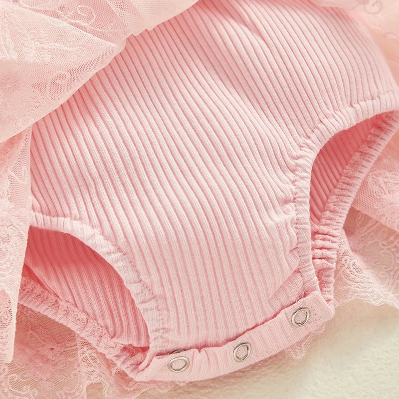 Close-up of built-in romper with snap closures on pink baby dress