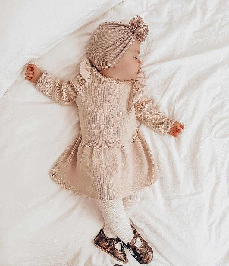 Sleeping baby girl wearing Poppy Winter Knit Dress in oatmeal from Lulu Babe