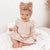 Baby girl wearing our Poppy Winter Dress in Oatmeal