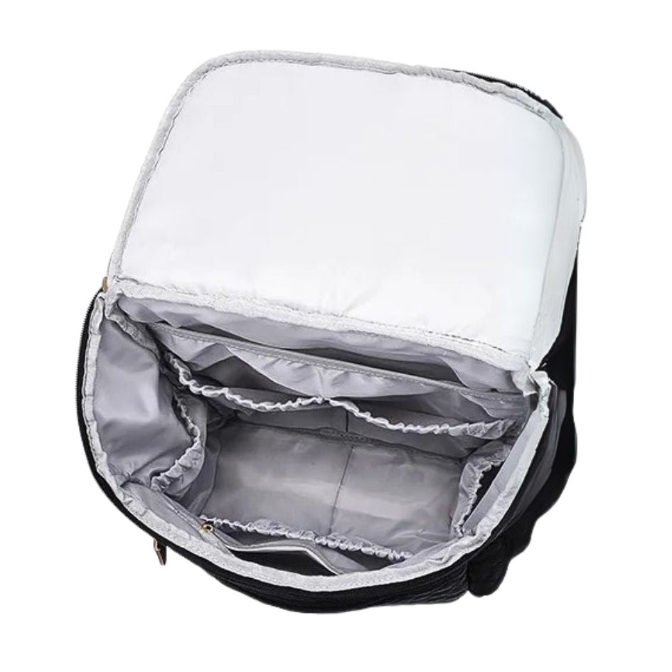 Interior view of a black quilted nappy backpack with multiple storage compartments for organised baby essentials.