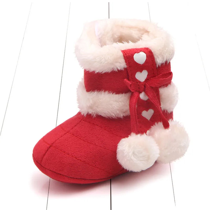 Red baby boots featuring faux fur lining, heart details, and fluffy pom poms