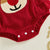 Close-up of the Reindeer Ruffle Romper in red featuring a cute reindeer face appliqué and snap button detailing for baby girl Christmas outfit.