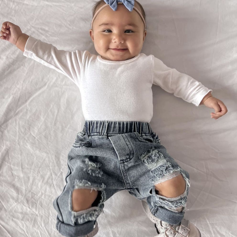 Baby girl wearing our distressed denim jeans
