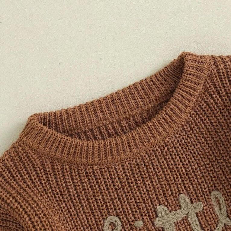 Matching sibling knit jumper in brown - closeup view