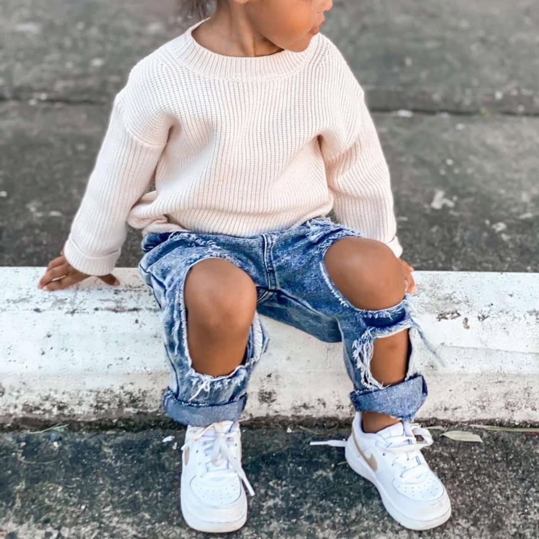 Toddler girl wearing trendy ripped jeans and knit jumper from Lulu Babe