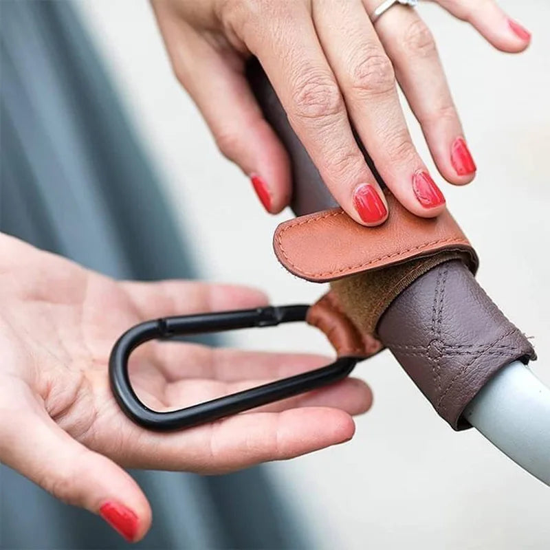 Universal Pram Clips showing velcro straps and aluminium clip on a stroller handle bar