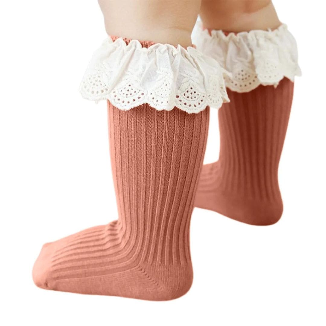 Baby wearing vintage lace knee high socks with ruffle trim in terracotta