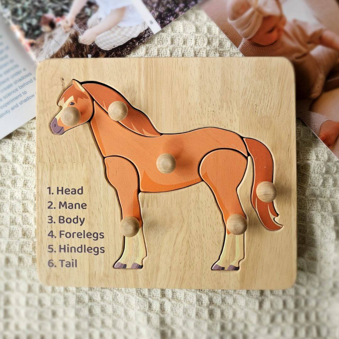 Wooden horse knob puzzle with six knobbed pieces and a printed parts list, on a cream knit blanket