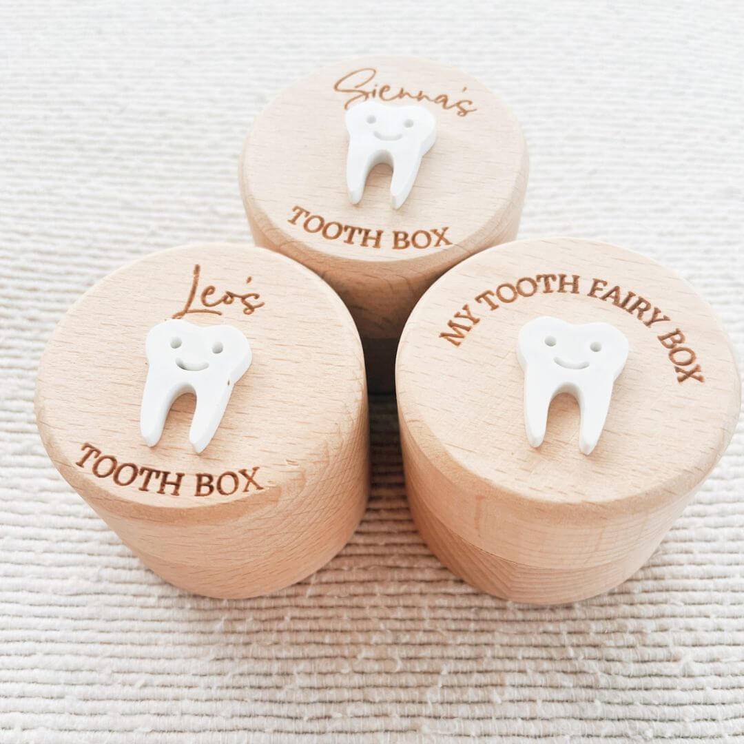 Three round beechwood tooth fairy boxes with personalised names and white 3D tooth detail on lids