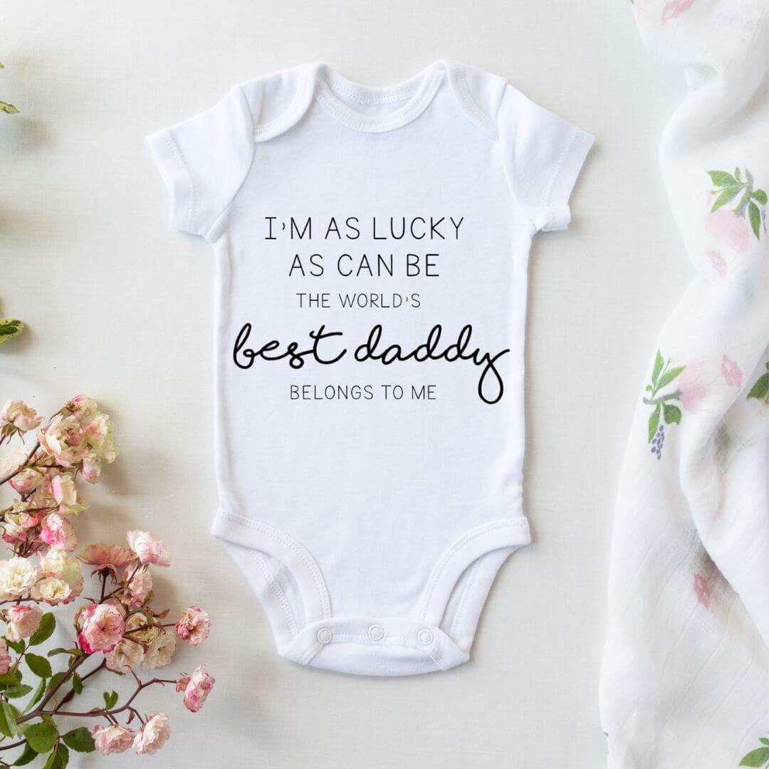 White baby bodysuit with "I'm as lucky as can be, the world's best daddy belongs to me" print