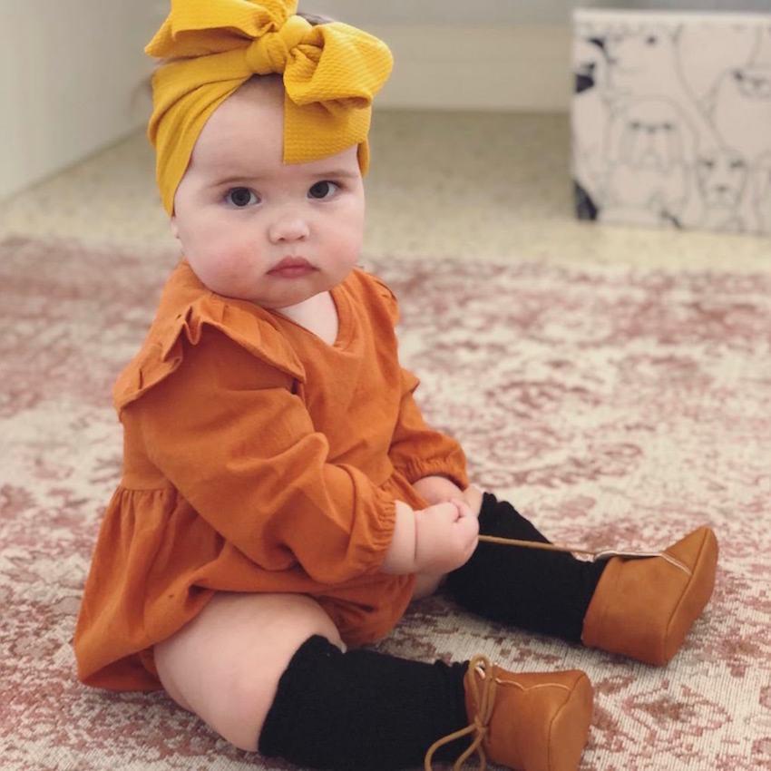 Cute baby girl wearing mustard bow headband from Lulu Babe