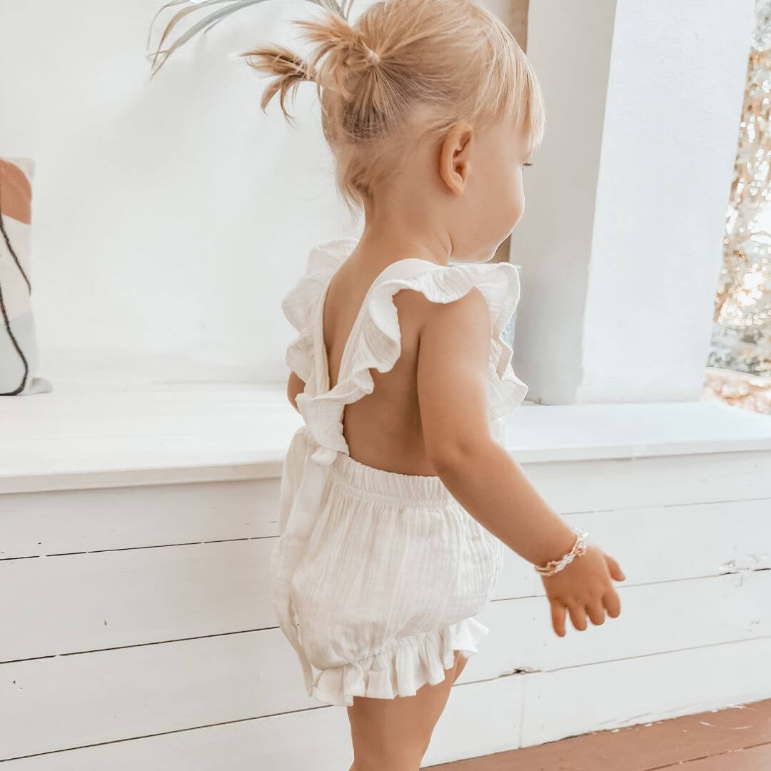 Toddler girl wearing the white Willow Ruffle Romper