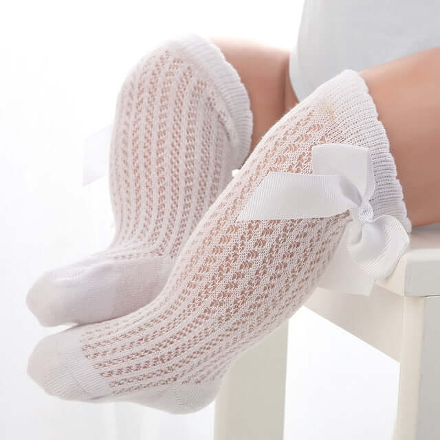 Lace knee-high baby girl socks in white, with large satin bow
