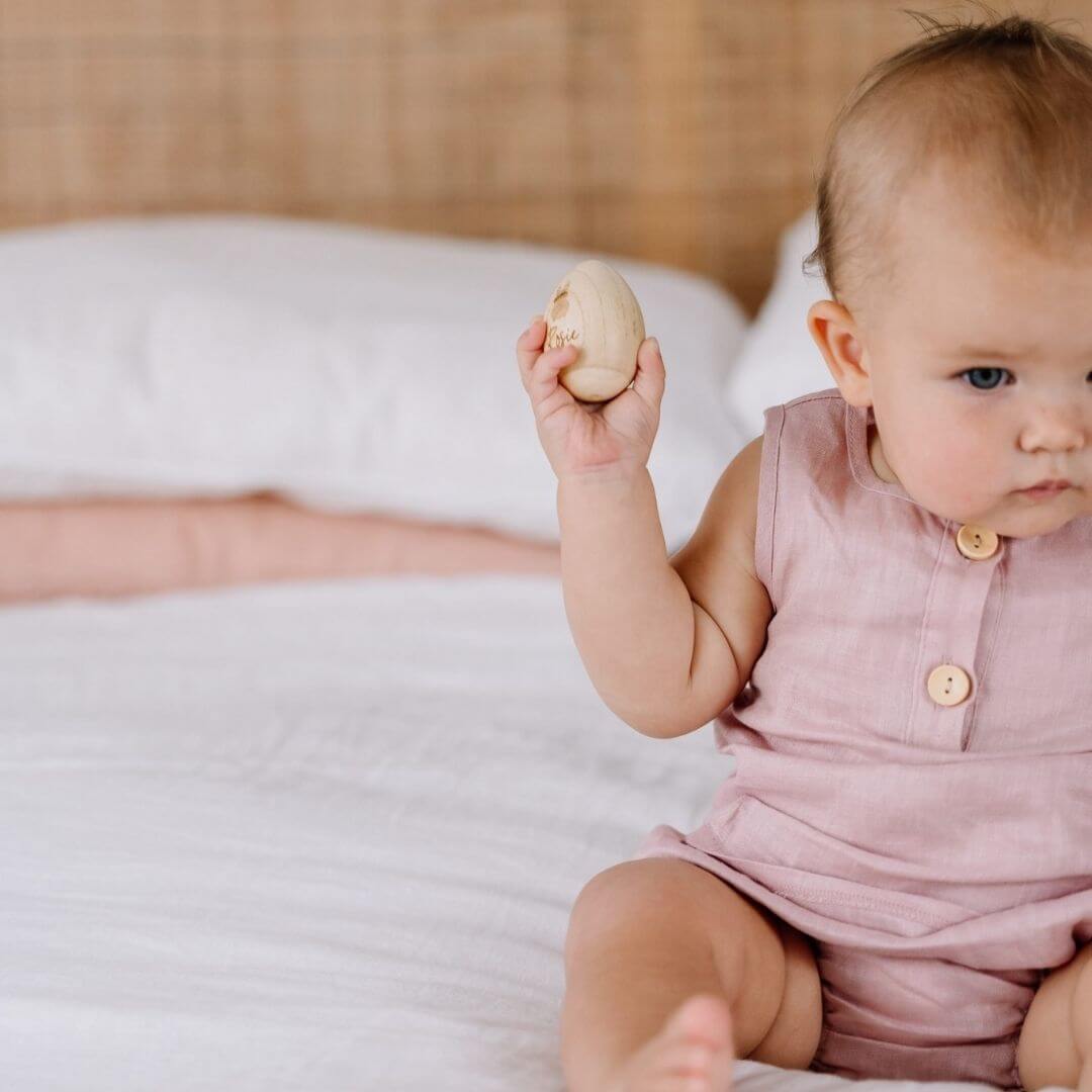 Baby holding personalised Wooden Christmas Egg Shaker - Lulu Babe