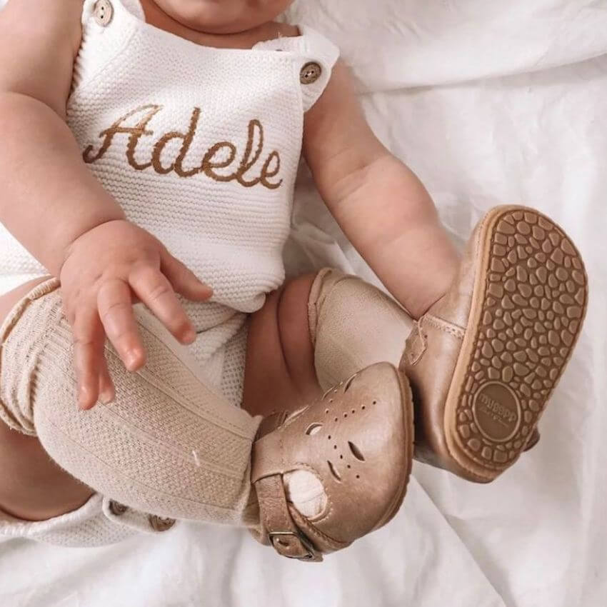 Baby wearing Cutout T-Bar Baby Shoes in beige vegan leather