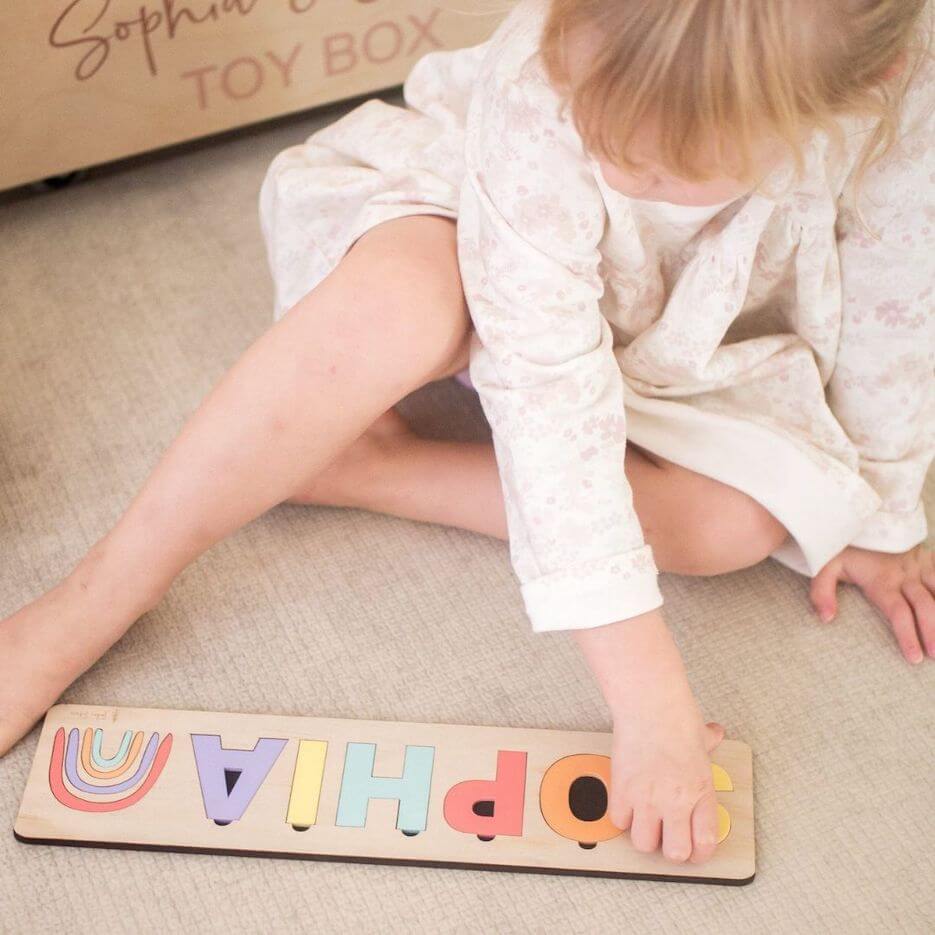 Girl playing with her customised name puzzle from Lulu Babe - made with 3 letters, 4 letters, 5 letters, 6 letters or more
