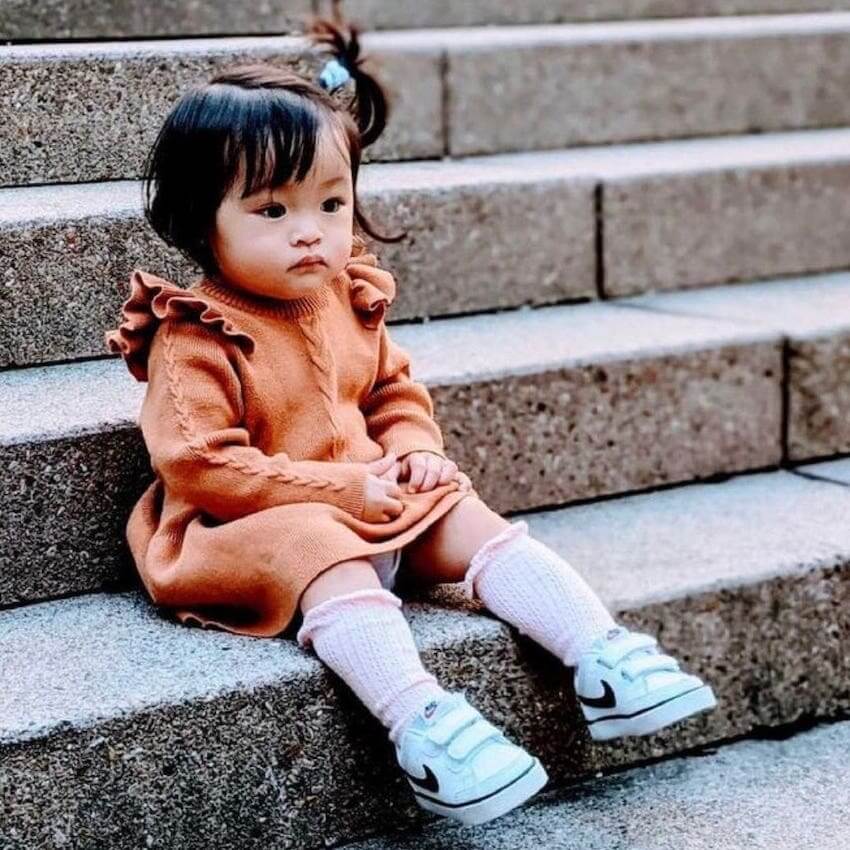 Baby girl wearing Poppy Winter Knit Dress in cinnamon from Lulu Babe